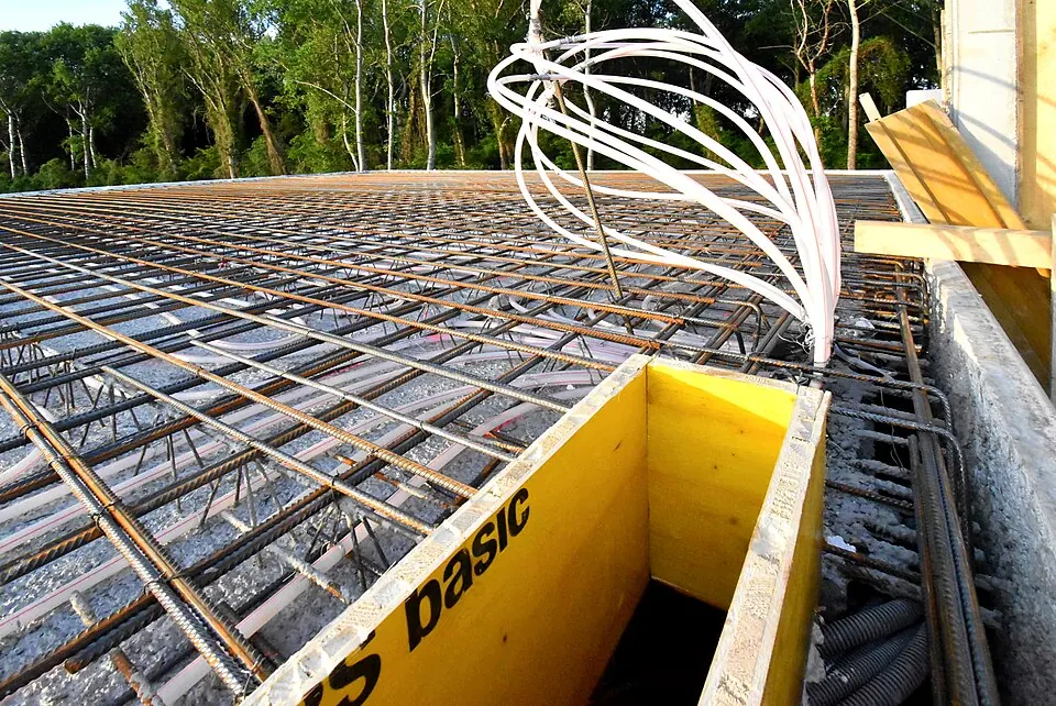 Boucles de chauffage au sol fixées sur un treillis d'armature, sur un chantier.